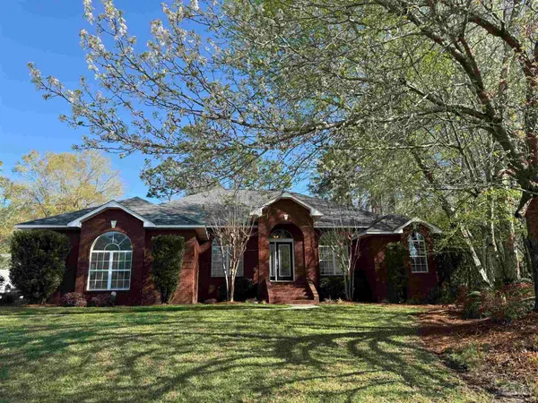 a view of a big house with a big yard and large trees