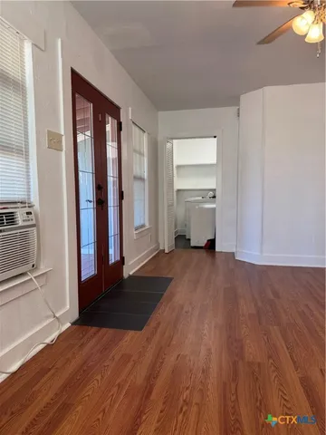a view of a room with wooden floor and a fan