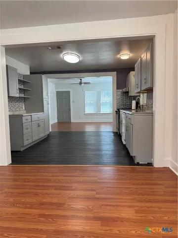 a view of empty room with wooden floor