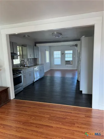 a view of a kitchen with wooden floor and a window