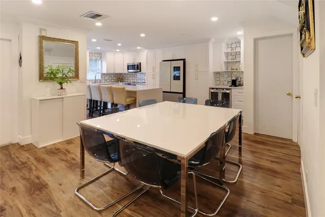 a kitchen with kitchen island a stove a table and chairs in it