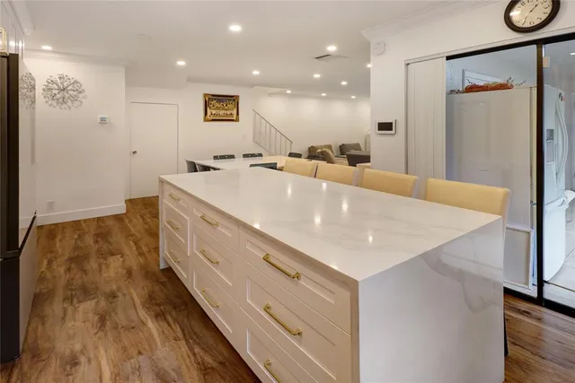 a large white kitchen with a large window