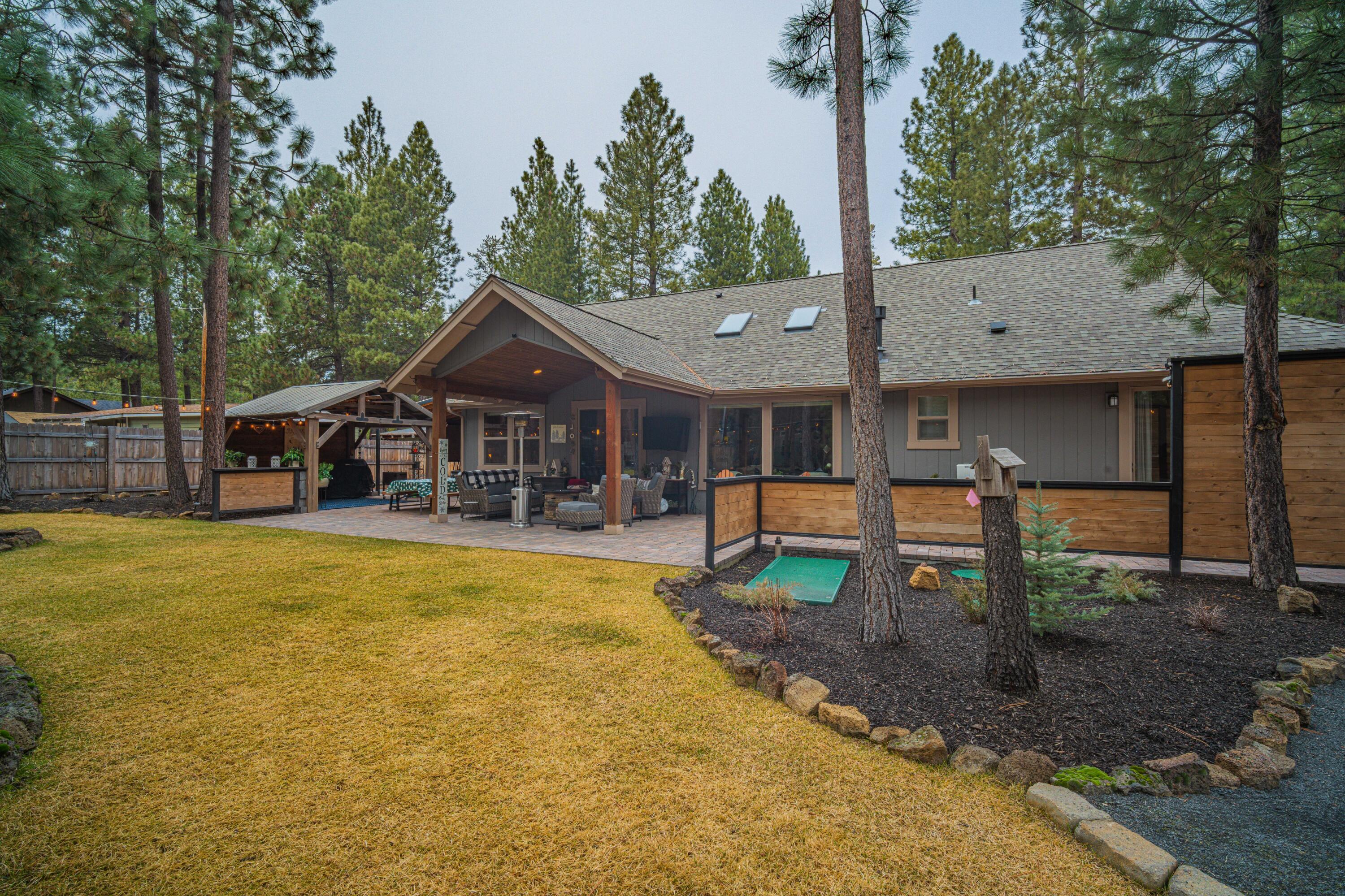 16927 Covina Road Bend, OR 97707 - Photo 49 of 54 Broad backyard view in this Bend, Oregon property showcasing the covered patio, hardscape, and layered outdoor living spaces that create a true oasis.