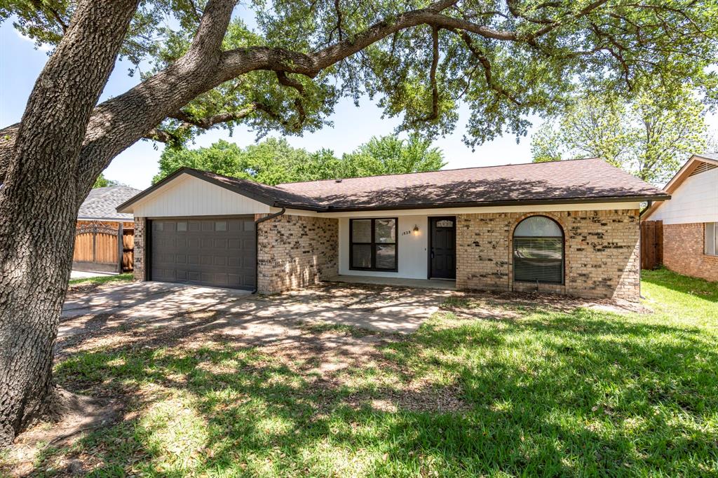 a front view of a house with a garden and yard