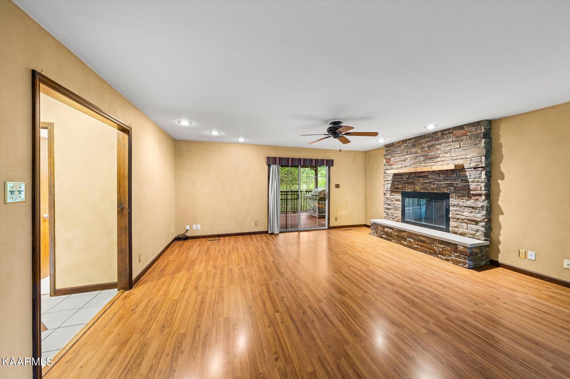 127 Chestnut Hill Road Oak Ridge, TN 37830 - Photo 9 of 45 an empty room with wooden floor fireplace and windows