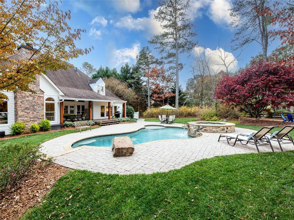 15230 Highgrove Road Milton, GA 30004 - Photo 1 of 1 a front view of a house with garden and swimming pool