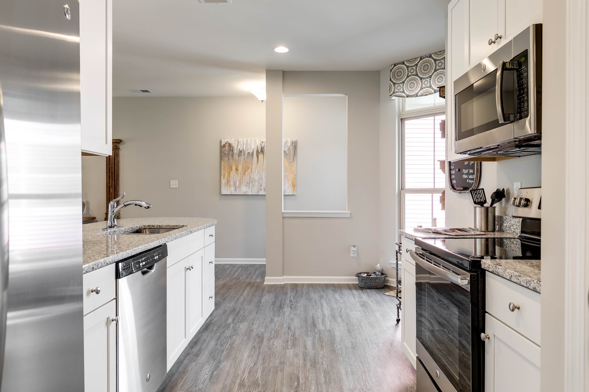 105 Keelon Gap Road Spring Hill, TN 37174 - Photo 5 of 8 a kitchen with stainless steel appliances a sink dishwasher a stove and a microwave oven with wooden floor