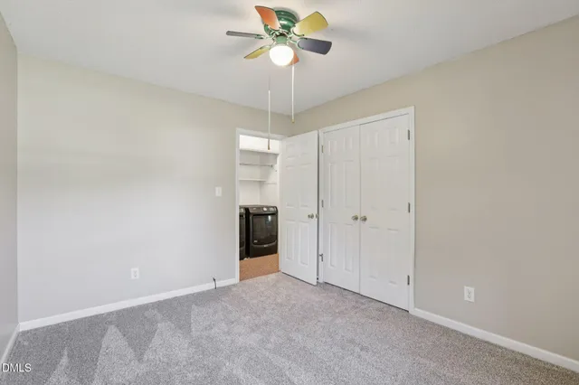 a view of an empty room and a ceiling fan