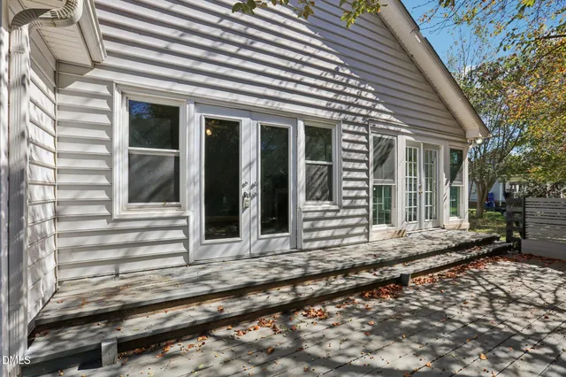 a view of a house with a small yard and wooden floor and fence