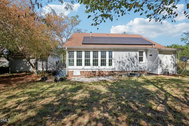 a view of a house with backyard and sitting area