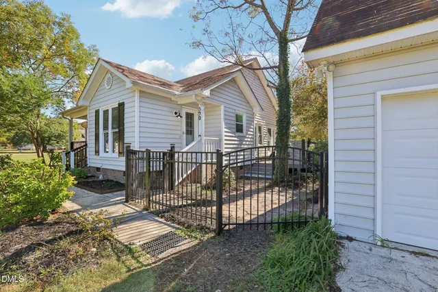 a view of a house with a small yard and wooden fence