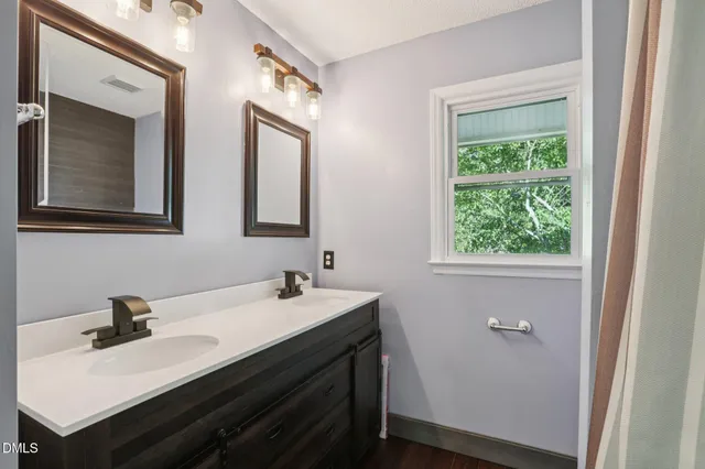 a bathroom with a sink and two mirror
