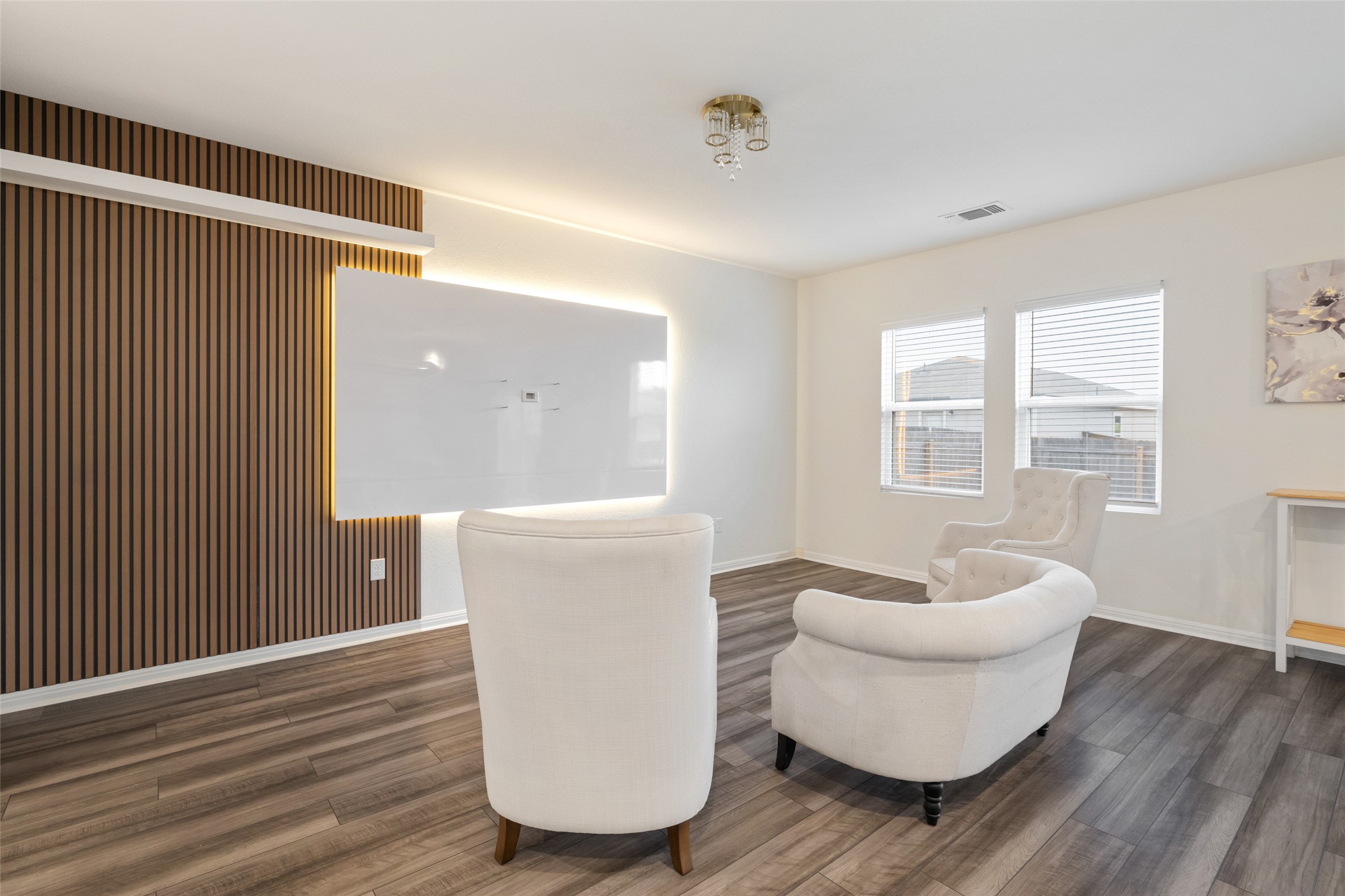 261 Night Riders Way Jarrell, TX 76537 - Photo 6 of 6 Recessed lighting and a unique slatted accent wall create a welcoming atmosphere in this well-lit living area.