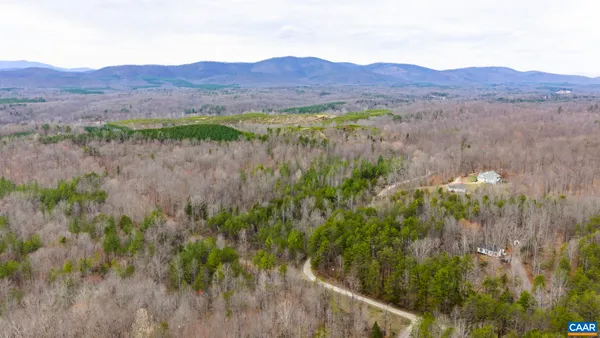 a view of a lake with a yard and large trees