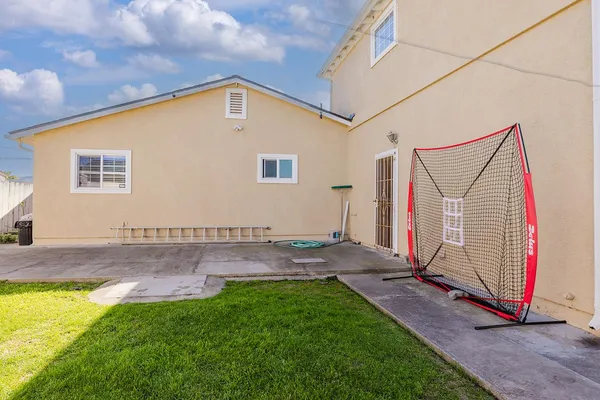 a view of a house with a small yard and wooden fence
