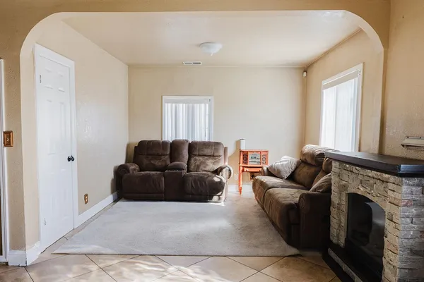 a living room with furniture a fireplace and a window