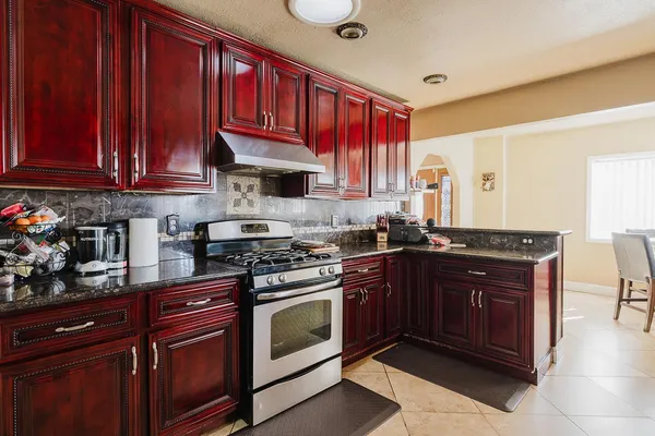 a kitchen with stainless steel appliances granite countertop a refrigerator and a stove