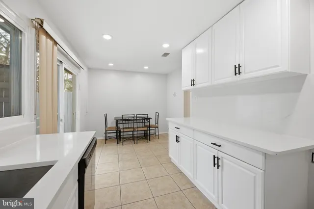 a hallway with a large window and white stainless steel appliances