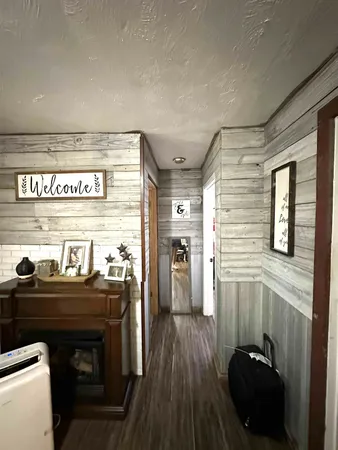 a view of a hallway with wooden floor and furniture