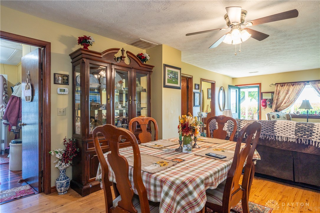 1599 Garringer Road Jamestown, OH 45335 - Photo 7 of 73 This inviting dining area features warm hardwood flooring, providing a comfortable space for gatherings.
