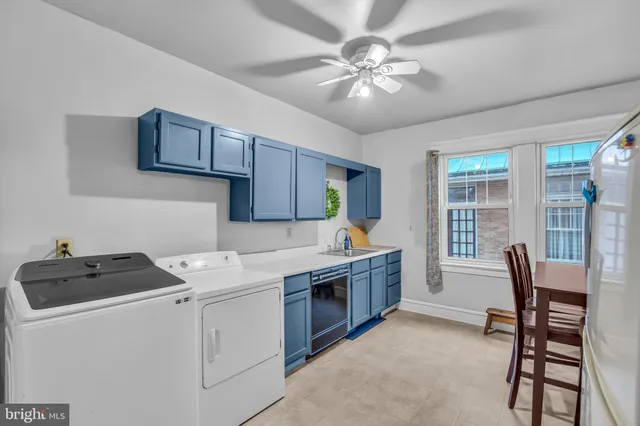 a kitchen with stainless steel appliances granite countertop a table chairs sink and cabinets