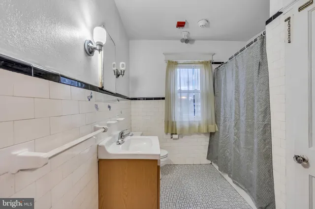 a kitchen with stainless steel appliances a stove a refrigerator and white cabinets with wooden floor