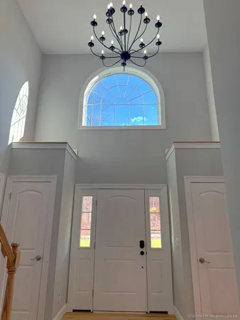 wooden floor with a chandelier