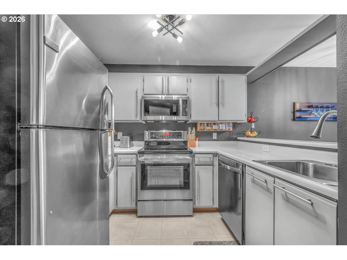 5142 Southwest Multnomah Boulevard, Unit H Portland, OR 97219 - Photo 12 of 26 a kitchen with kitchen island a counter top space appliances and cabinets
