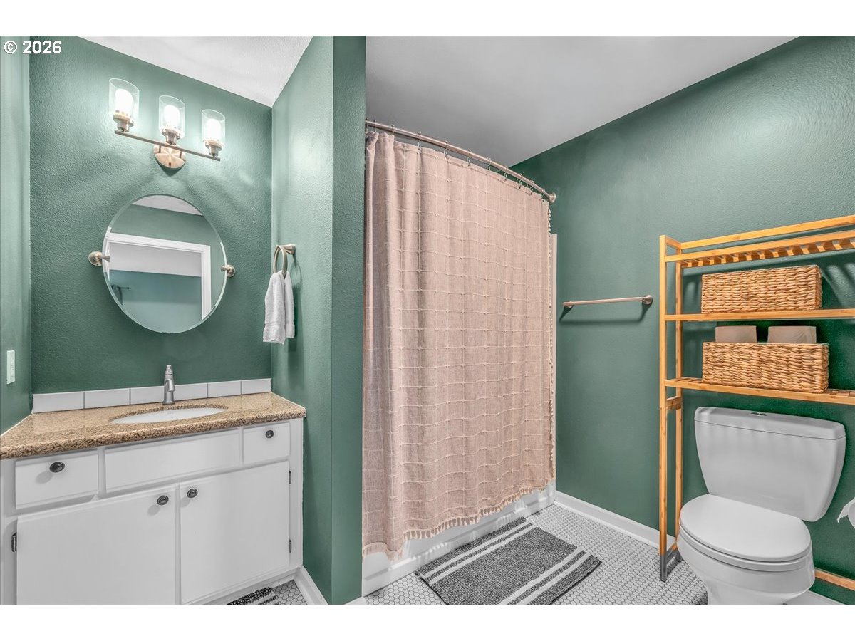 5142 Southwest Multnomah Boulevard, Unit H Portland, OR 97219 - Photo 16 of 26 a bathroom with a toilet a sink and mirror