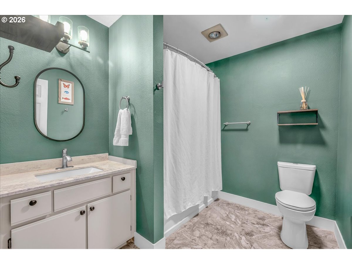 5142 Southwest Multnomah Boulevard, Unit H Portland, OR 97219 - Photo 21 of 26 a bathroom with a toilet sink and mirror