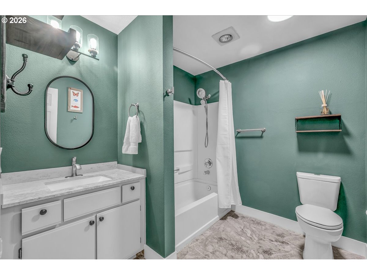 5142 Southwest Multnomah Boulevard, Unit H Portland, OR 97219 - Photo 23 of 26 a bathroom with a toilet sink and mirror