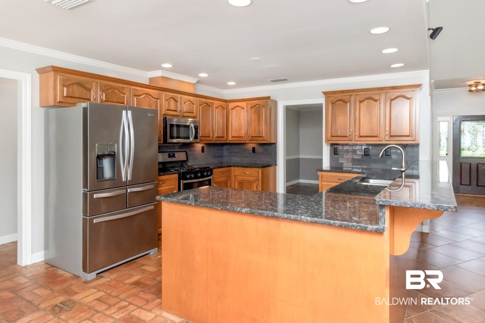 10691 Hunters Ridge Drive Mobile, AL 36695 - Photo 12 of 37 Kitchen featuring wood cabinetry, stainless steel appliances, dark stone countertops, and a tile backsplash
