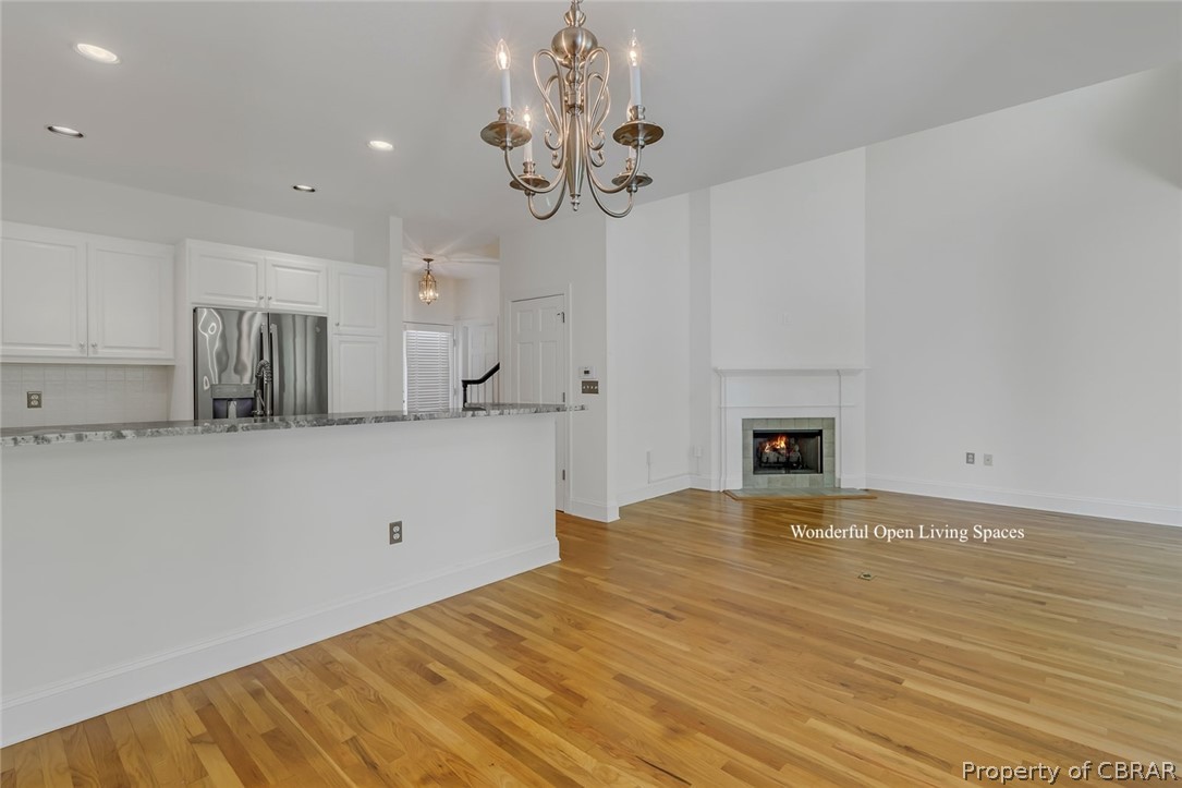 5818 Rivers Landing Terrace, Unit 5818 White Stone, VA 22578 - Photo 15 of 50 Unfurnished living room with light hardwood / wood-style floors and a notable chandelier