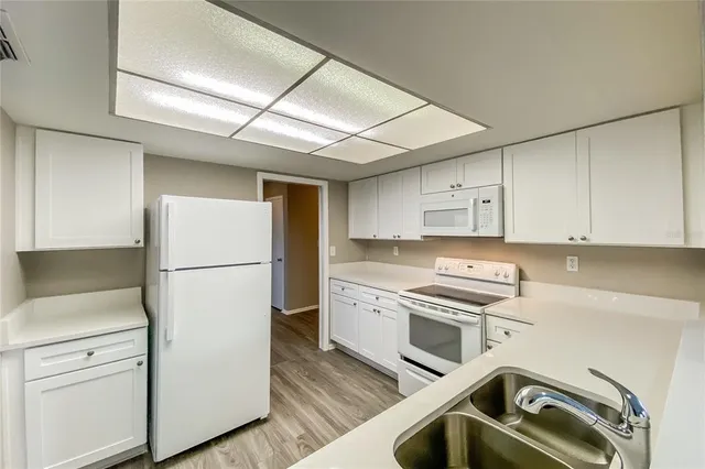 a kitchen with a refrigerator a stove a microwave and cabinets