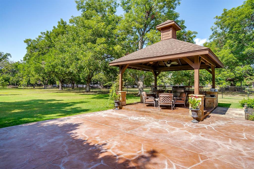 6251 Paper Shell Way Fort Worth, TX 76179 - Photo 32 of 40 a view of backyard with table and chairs under an umbrella with a barbeque