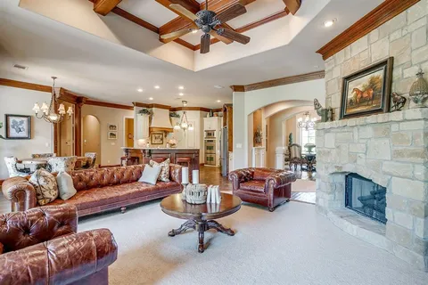 a living room with furniture fireplace and a ceiling fan