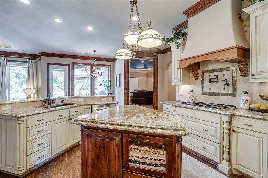 6251 Paper Shell Way Fort Worth, TX 76179 - Photo 10 of 40 a kitchen with granite countertop a sink a stove cabinets and wooden floor