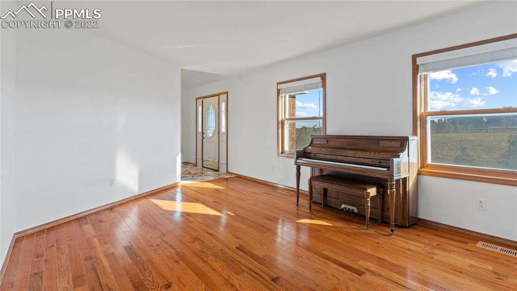 16250 Herring Road Colorado Springs, CO 80908 - Photo 12 of 50 a view of empty room with wooden floor and fireplace