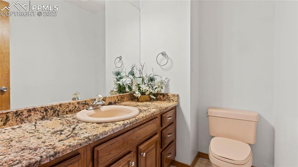 16250 Herring Road Colorado Springs, CO 80908 - Photo 15 of 50 a bathroom with a granite countertop sink toilet and mirror