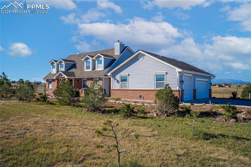 16250 Herring Road Colorado Springs, CO 80908 - Photo 40 of 50 a front view of house with yard and trees in the background
