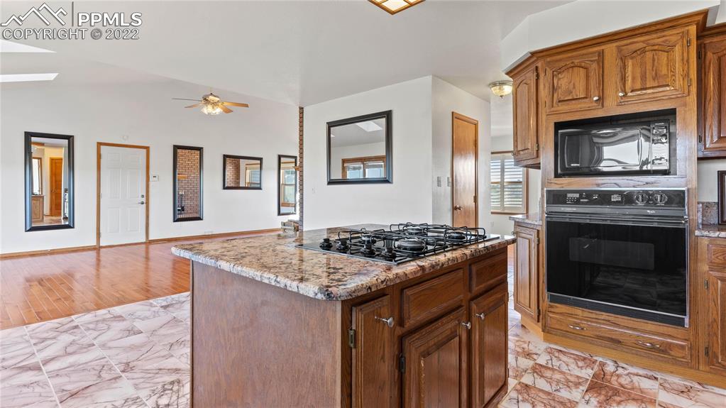 16250 Herring Road Colorado Springs, CO 80908 - Photo 5 of 50 a kitchen with stainless steel appliances granite countertop a stove oven and a refrigerator with wooden floor
