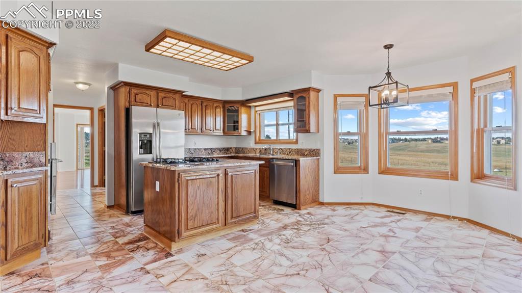 16250 Herring Road Colorado Springs, CO 80908 - Photo 7 of 50 a kitchen with stainless steel appliances granite countertop a refrigerator and a stove top oven