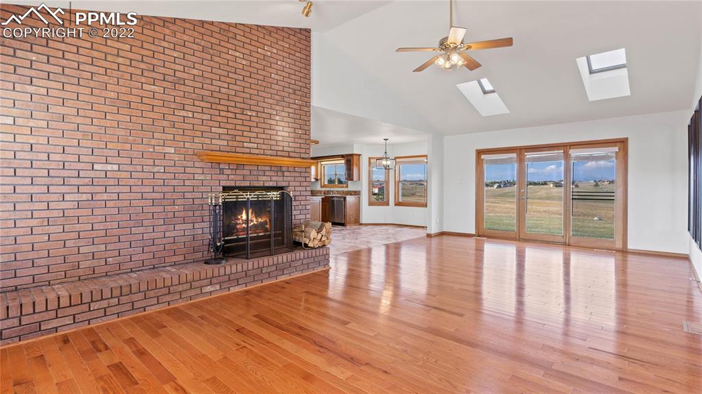 16250 Herring Road Colorado Springs, CO 80908 - Photo 10 of 50 a view of empty room with fireplace and wooden floor