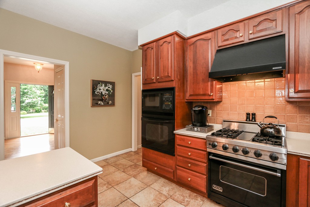12 Bellows Road Wilbraham, MA 01095 - Photo 10 of 30 a kitchen with stainless steel appliances a stove a microwave and wooden cabinets