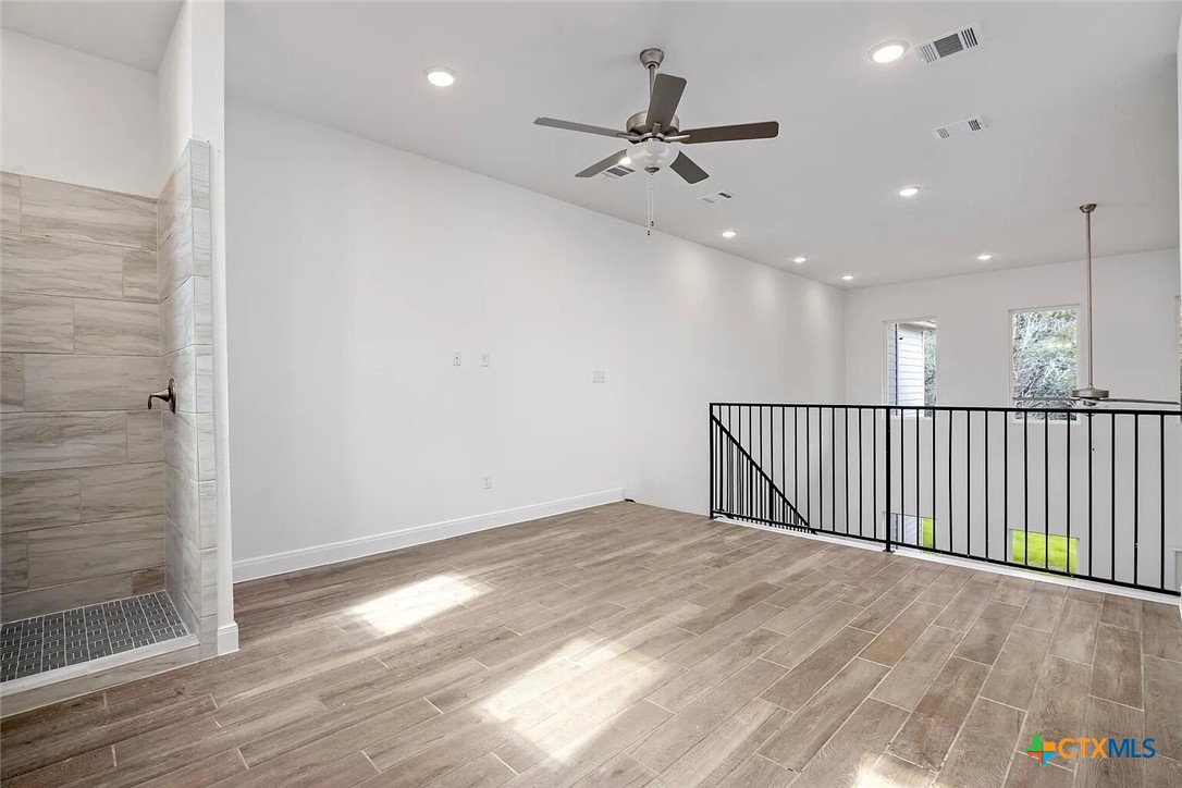 155 North Rip Ford Road, Unit B Spring Branch, TX 78070 - Photo 11 of 17 an empty room with wooden floor fan and windows