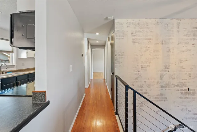 a view of a hallway with wooden floor and staircase