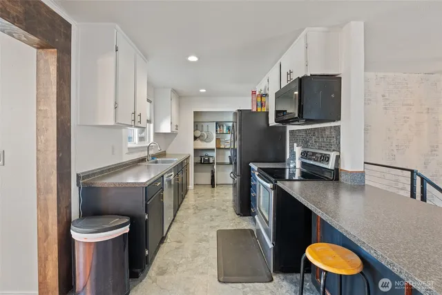 a kitchen with stainless steel appliances granite countertop a sink a stove and a refrigerator