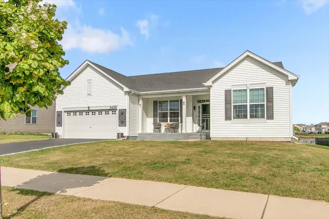 a view of a house with a yard and large tree