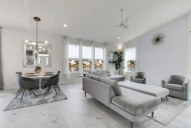 a living room with furniture a chandelier and a dining table with wooden floor