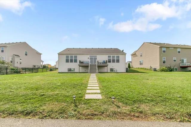 a view of a big house with a big yard and large trees